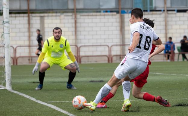 Delgado, cubierto por un defensor del Comillas, intenta disparar a puerta ante el portero Álex. / FERNANDO DÍAZ