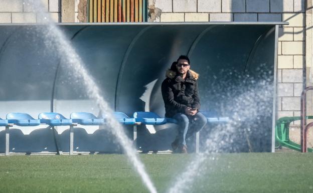 Dupi, sentando en el banquillo, sigue un entrenamiento de la UD Logroñés. / FERNANDO DÍAZ