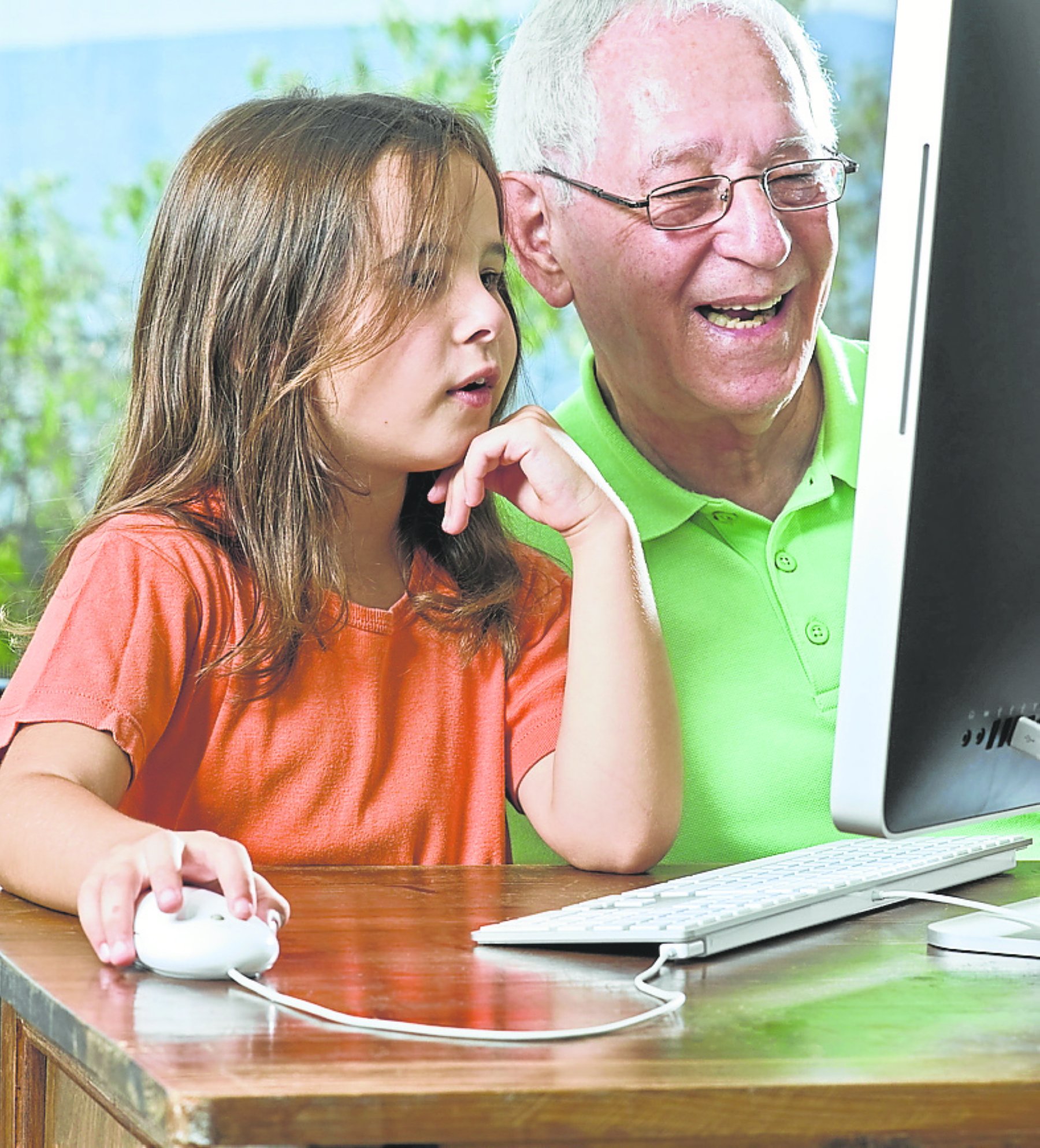 Un abuelo observa a su nieta jugar en el ordenador. / L.R.