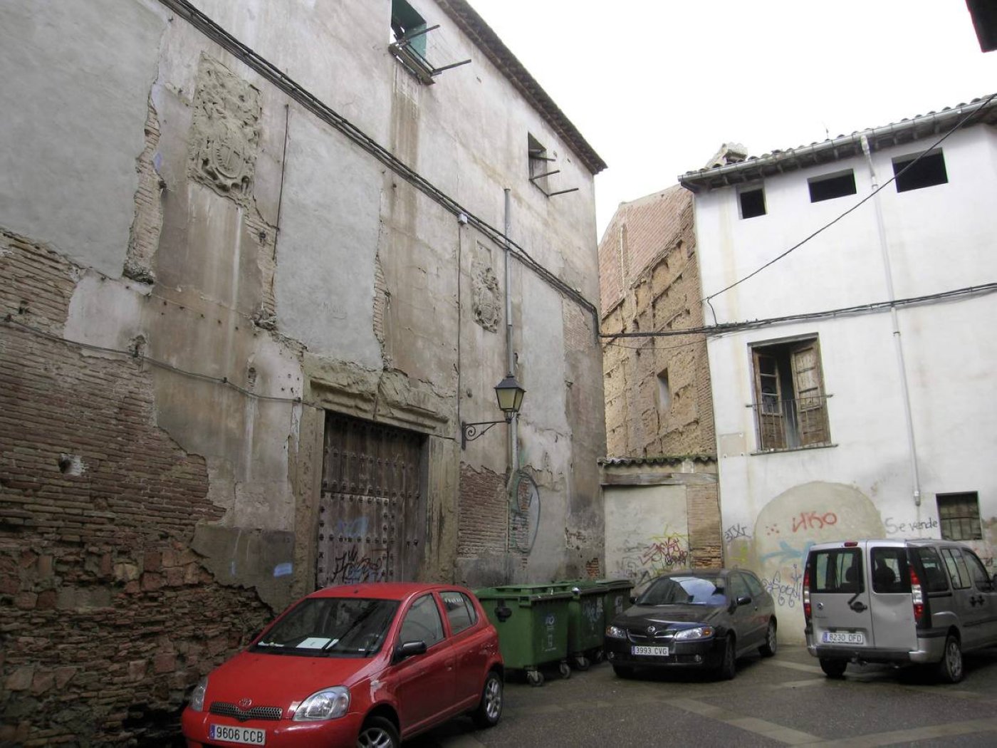 Estado en el que se encontraba la Casa de las Medranas antes de ser derribada en 2015 y una imagen de detalle de uno de sus dos escudos. / I. Á.