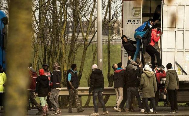 Inmigrantes ilegales suben a un camión en la comuna francesa de Calais/AFP